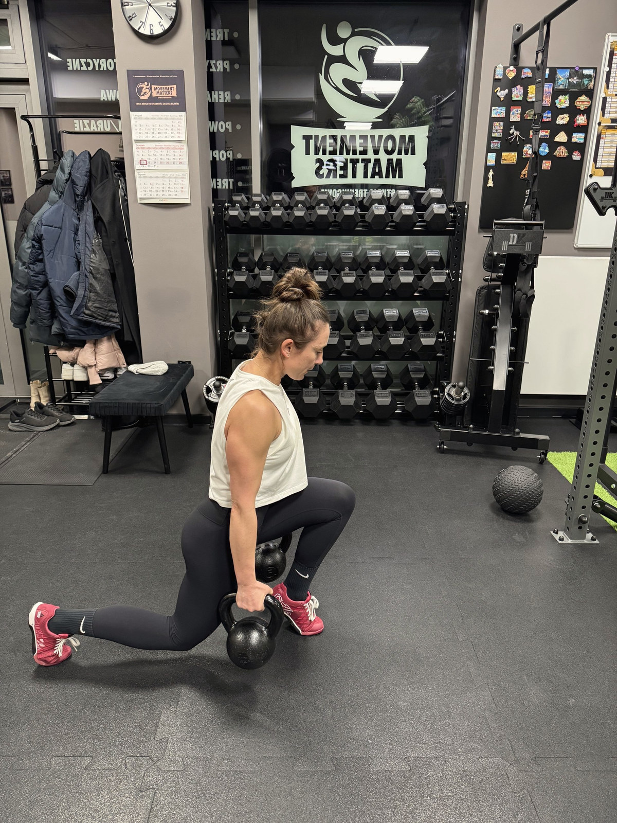 Podopieczna wykonuje wykrok z kettlebell w studiu Movement Matters